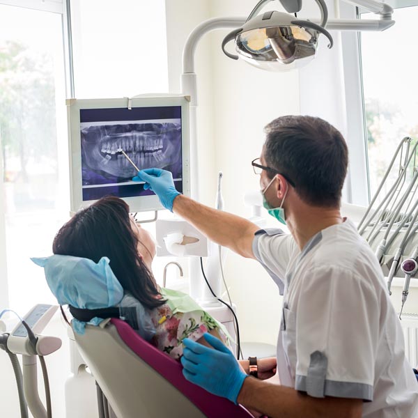 dentist showing x-ray to woman in dental chair