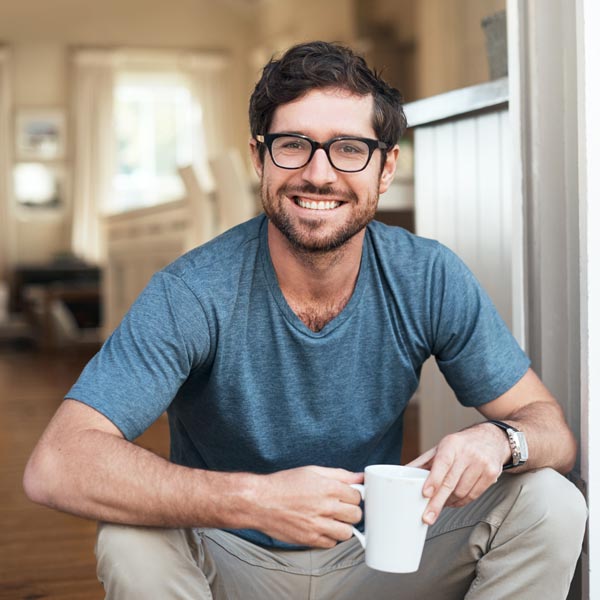 man smiling with cup of coffee
